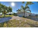 Well-maintained home boasts a two-car garage, brick driveway, and lush landscaping at 410 Majestic Gardens Blvd, Winter Haven, FL 33880