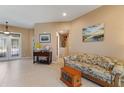 Inviting living room showcasing tile flooring, neutral paint, elegant furniture, and abundant natural light at 410 Majestic Gardens Blvd, Winter Haven, FL 33880