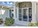 Inviting front porch with decorative columns, screened door, and neatly trimmed bushes at 4419 Clear Brook Ct, Leesburg, FL 34748