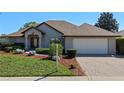 Well-maintained home with a brick driveway, manicured lawn, and a two-car garage under a clear sky at 4571 Abaco Dr, Tavares, FL 32778