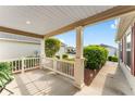 Inviting covered front porch with classic columns and meticulous landscaping at 5675 Herman Ave, The Villages, FL 32163