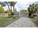 Charming single-story home featuring a beautifully paved driveway and well-maintained landscaping at 756 Heathrow Ave, The Villages, FL 32159