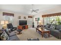 Comfortable living room with plush seating, a ceiling fan, and natural light at 859 Parksville Path, The Villages, FL 32162