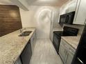Galley kitchen with granite countertops, stainless steel appliances, and light gray cabinets at 1000 Royal Oak Blvd, Leesburg, FL 34748