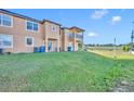 Back exterior view featuring a large grassy yard, patio, and balcony with black railings at 1144 Calabria Ave, Davenport, FL 33897