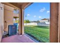 View of a covered back patio, overlooking a large grassy yard with a white privacy fence at 1144 Calabria Ave, Davenport, FL 33897