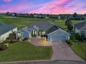 Beautiful single-story home with lush landscaping, brick driveway, and a two-car garage at 11743 Se 174Th Loop, Summerfield, FL 34491