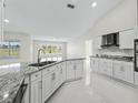 Modern kitchen with granite counters, white cabinets, and stainless steel appliances at 11743 Se 174Th Loop, Summerfield, FL 34491