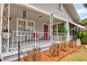 Inviting front porch with decorative railings, a red door, and a cozy seating area at 1515 Washington Ave, Eustis, FL 32726