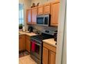 Well-equipped kitchen featuring light wood cabinets, stainless steel appliances, and neutral countertops at 155 Crepe Myrtle Dr, Groveland, FL 34736