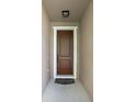 A wood front door with white trim and a decorative welcome mat at 1568 Brandywine Dr, Tavares, FL 32778