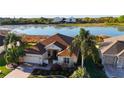 Beautiful home with water view, mature palms, pristine landscaping, and tile roof at 1721 Carrera Dr, The Villages, FL 32159