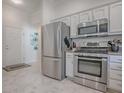 Modern kitchen featuring stainless steel appliances, white cabinets, and tile floors at 1829 Foxwood Ln, The Villages, FL 32162