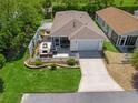 Aerial view of a charming house with an outdoor seating area and a screened porch, surrounded by lush landscaping at 2234 Braxton St, The Villages, FL 32162