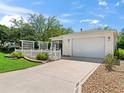 Charming home with a white picket fence and well-manicured landscaping, plus a convenient attached garage and a long driveway at 2234 Braxton St, The Villages, FL 32162