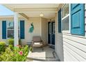 Inviting front porch with a chair, blue shutters, and a peacock decoration, creating a warm welcome at 2330 Camden Ter, The Villages, FL 32162