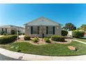 Landscaped front yard with manicured bushes, rocks and a decorative tree in the center at 2330 Camden Ter, The Villages, FL 32162