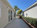 Exterior view of a well-maintained home showcasing desert landscaping and a concrete walkway between neighboring homes at 2523 Mariel Way, The Villages, FL 32162