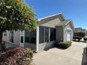 Cozy single-story home featuring a screened-in lanai, desert landscaping, and an attached two-car garage at 2523 Mariel Way, The Villages, FL 32162