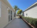 Home exterior with a manicured landscape with small walkway in between houses at 2523 Mariel Way, The Villages, FL 32162