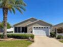 Inviting single-story home featuring a well-manicured lawn and a classic white garage door at 2523 Mariel Way, The Villages, FL 32162