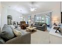 Spacious living room featuring vaulted ceilings, neutral decor, and sliding glass doors at 25239 River Crest Dr, Leesburg, FL 34748