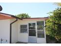Sunroom exterior with a glass door entry and adjacent awning windows at 5221 Se 107Th Pl, Belleview, FL 34420