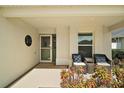 Inviting front porch with seating area, plants, and decorative details near the entrance of the home at 557 Harlow Ln, The Villages, FL 32163