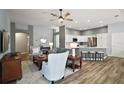 Spacious living room with hardwood floors open to the kitchen with modern countertops and bar stool seating at 557 Harlow Ln, The Villages, FL 32163