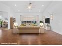 Staged living room features vaulted ceilings, a ceiling fan, and sliding glass doors leading to the lanai at 5953 Sailboat Ave, Tavares, FL 32778