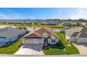 Lovely single-Gathering home with a three-car garage and colorful stone driveway overlooking a picturesque pond at 6126 Mulligan Run, The Villages, FL 32163