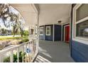 Spacious porch featuring white railings and blue siding, offering a cozy outdoor space at 7549 Frog Log Ln, Leesburg, FL 34748