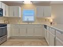 Bright kitchen featuring granite countertops, stainless appliances and white cabinetry at 880 Radclife Berea Pl, The Villages, FL 32162
