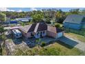 Aerial view of the charming pink home with a spacious yard, RV, and a covered front porch at 910 Rich Dr, Mount Dora, FL 32757