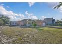 View of the backyard showcasing the home's exterior, RV parking, and lawn at 910 Rich Dr, Mount Dora, FL 32757