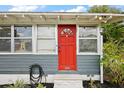 Close-up of the bright red front door, complemented by stylish exterior details at 952 W Montrose St, Clermont, FL 34711