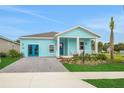 Inviting single-Gathering home with bright blue exterior, stone driveway, and a quaint covered front porch at 981 Fiesta Key Cir, Lady Lake, FL 32159