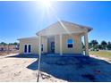 New single-story home under construction featuring a covered porch with classic columns and a bright, airy design at 981 Fiesta Key Cir, Lady Lake, FL 32159