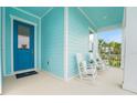 Relaxing porch with rocking chairs and a stylish blue door, perfect for enjoying quiet moments at 981 Fiesta Key Cir, Lady Lake, FL 32159