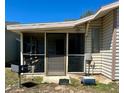 Exterior shot of a screened-in porch with access door to the home's vinyl siding at 10301 Us Highway 27 # 84, Clermont, FL 34711