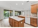 Close-up view of the bright kitchen featuring wood cabinets, white appliances, and a center island with bar seating at 11759 Se 91St Cir, Summerfield, FL 34491