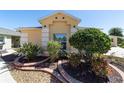 Landscaped front yard featuring tropical plants and colorful flowers near the entrance at 1907 Anderson Ct, The Villages, FL 32162
