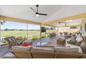 Relaxing lanai with comfortable seating and ceiling fans with a view of the golf course at 1907 Anderson Ct, The Villages, FL 32162