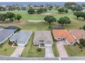 Aerial view of the home with a golf course and water views in the distance with neighboring houses at 30454 Island Club Dr, Deer Island, FL 32778