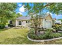 Beautiful home featuring a well manicured lawn, mature trees, and a two-car garage at 6152 Topsail Rd, Lady Lake, FL 32159