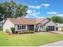 Well-maintained one-story home boasting green lawn, mature landscaping, and attached two-car garage at 6410 Tildon Ct, Leesburg, FL 34748