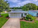 Well-maintained home showcasing a lush lawn and a convenient garage at 701 Cottage Park Ln, Leesburg, FL 34748