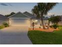 Charming single-story home features a manicured lawn, palm trees and a spacious two car garage with a clean driveway at 7539 Hagemeyer Pl, The Villages, FL 34762