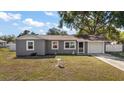 Single-story home boasts fresh exterior paint, attached garage and manicured lawn with a classic bird bath at 900 Maple Ave, Fruitland Park, FL 34731