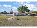 Single-story home features a freshly painted exterior, an American flag, and a meticulously kept yard at 900 Maple Ave, Fruitland Park, FL 34731